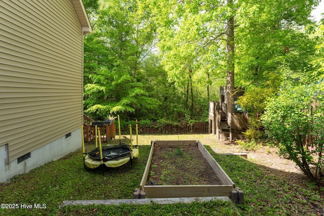 view of yard featuring fence and a garden