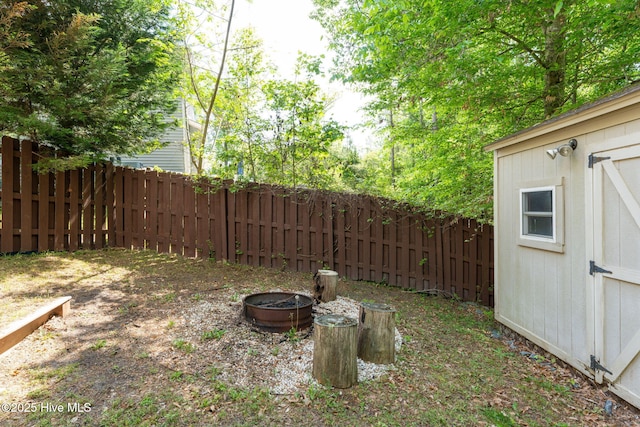 view of yard featuring an outdoor structure, a storage unit, and a fenced backyard