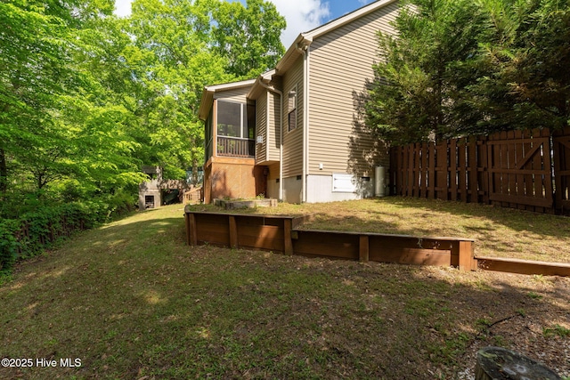 view of home's exterior with fence, a yard, and a sunroom