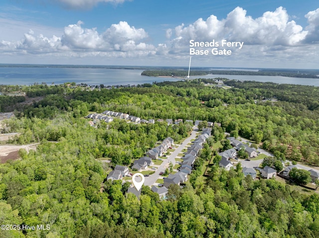 bird's eye view featuring a wooded view, a residential view, and a water view