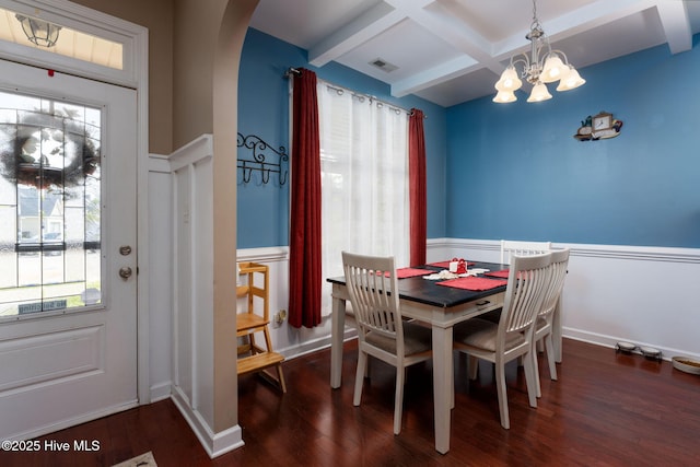 dining space featuring a notable chandelier, coffered ceiling, visible vents, arched walkways, and wood finished floors