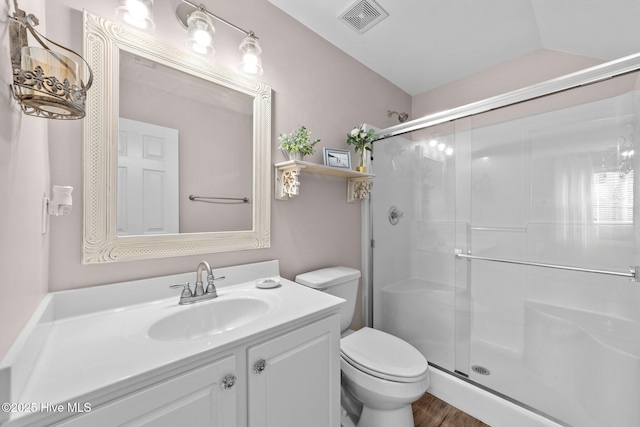 bathroom with visible vents, a stall shower, wood finished floors, vanity, and toilet