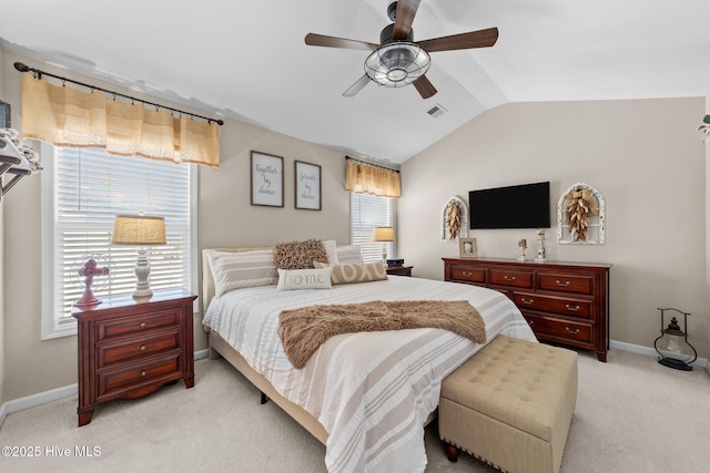 bedroom with a ceiling fan, visible vents, light colored carpet, vaulted ceiling, and baseboards