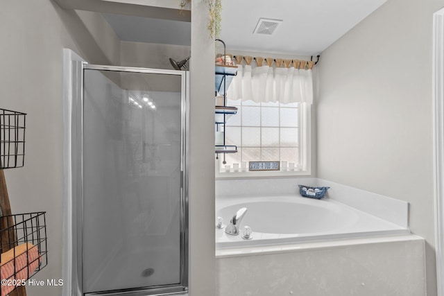 bathroom featuring visible vents, a shower stall, and a bath