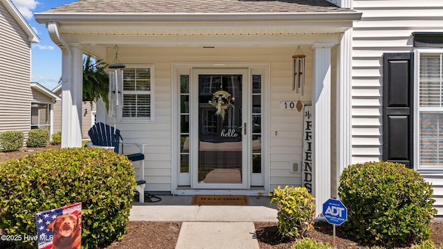property entrance featuring a shingled roof and a porch