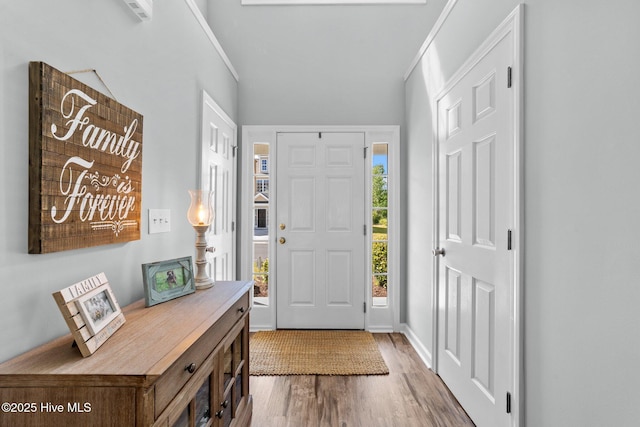 foyer entrance with baseboards and wood finished floors