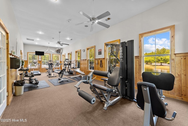 exercise room with ceiling fan, wainscoting, wood walls, recessed lighting, and visible vents