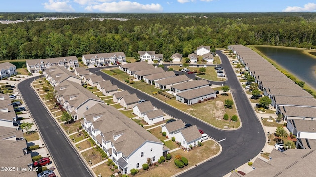 drone / aerial view with a residential view, a water view, and a wooded view