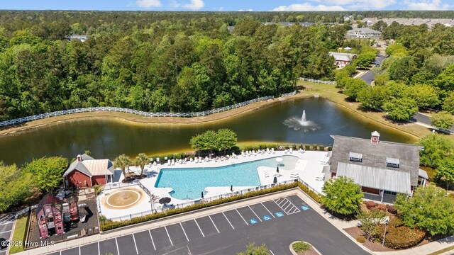birds eye view of property with a water view and a wooded view