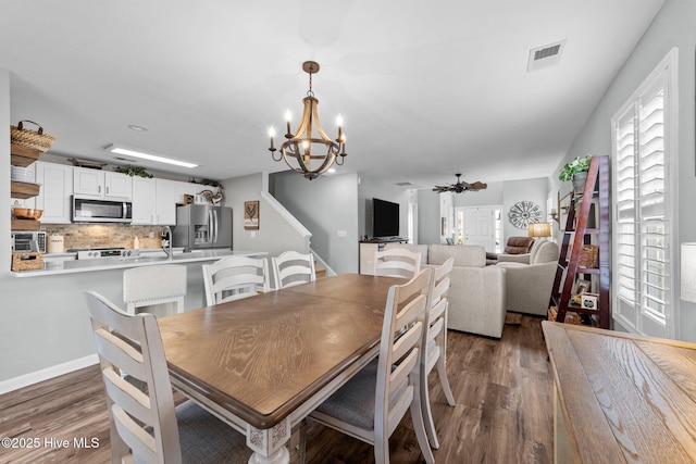 dining room featuring an inviting chandelier, plenty of natural light, visible vents, and dark wood-type flooring