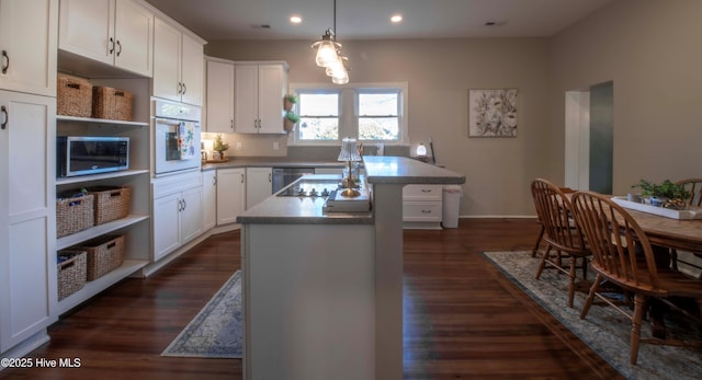 223 N Main St, Wendell, NC 27591 - kitchen featuring white cabinets, stainless steel appliances, a center island, recessed lighting, and dark wood-type flooring
