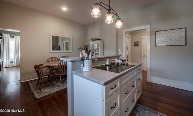 223 N Main St, Wendell, NC 27591 - kitchen featuring black electric cooktop, light countertops, white cabinetry, and dark wood finished floors
