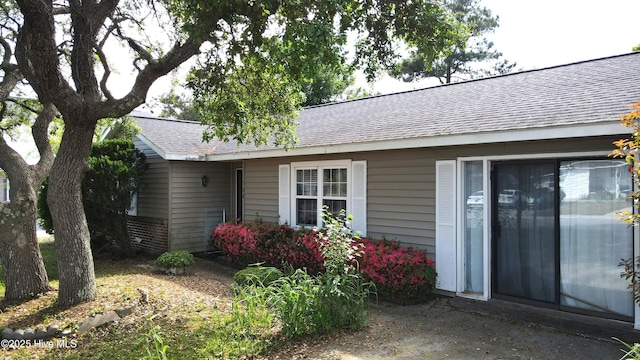 entrance to property featuring a shingled roof