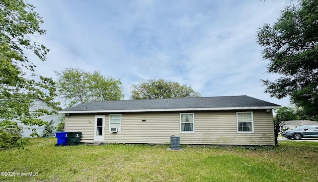back of house with a lawn and cooling unit