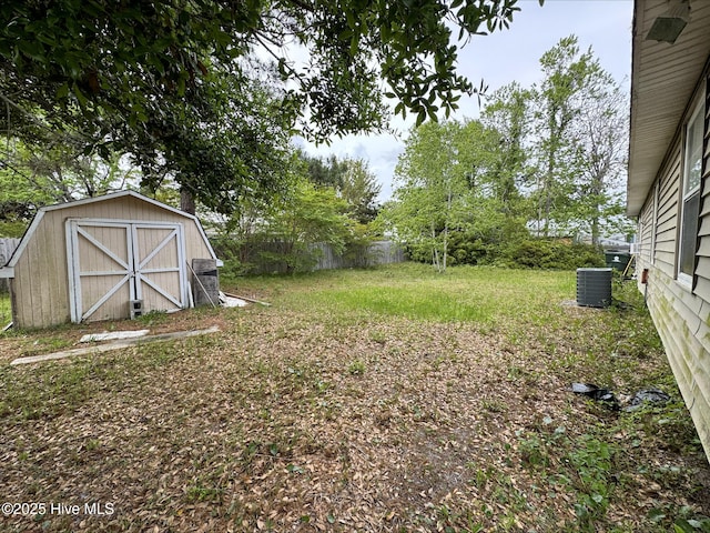 view of yard with cooling unit, a storage shed, an outbuilding, and fence