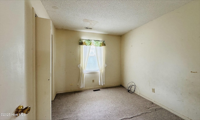 unfurnished room featuring carpet flooring, a textured ceiling, visible vents, and baseboards