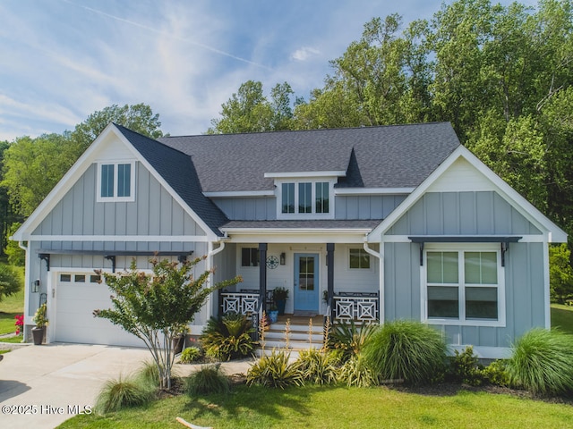 596 W Burton Farm Dr, Minnesott Beach, NC 28510 - view of front of house with covered porch, an attached garage, concrete driveway, board and batten siding, and a shingled roof