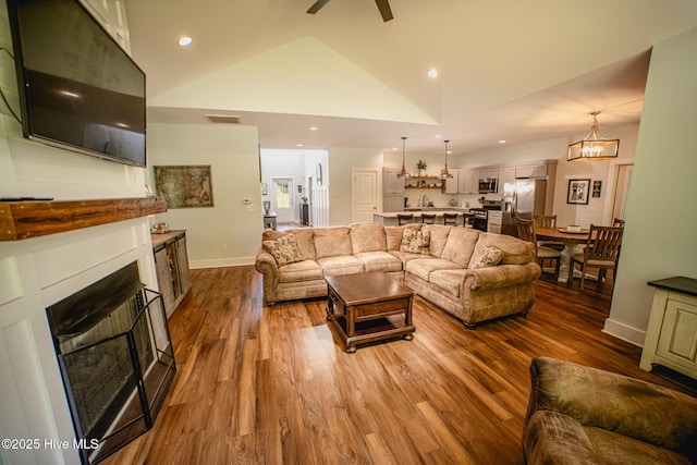 596 W Burton Farm Dr, Minnesott Beach, NC 28510 - living area with lofted ceiling, a fireplace, visible vents, and wood finished floors