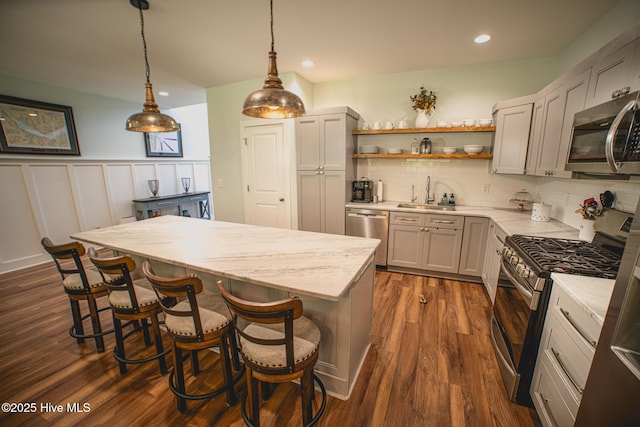 596 W Burton Farm Dr, Minnesott Beach, NC 28510 - kitchen featuring a center island, a sink, open shelves, a kitchen breakfast bar, and stainless steel appliances