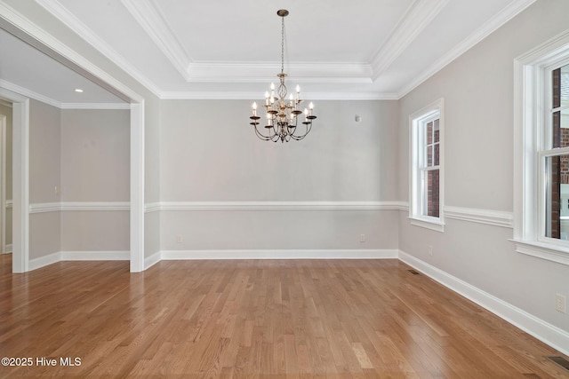 118 Legacy Oaks Dr, Wallace, NC 28466 - empty room with a chandelier, light wood finished floors, a tray ceiling, baseboards, and ornamental molding
