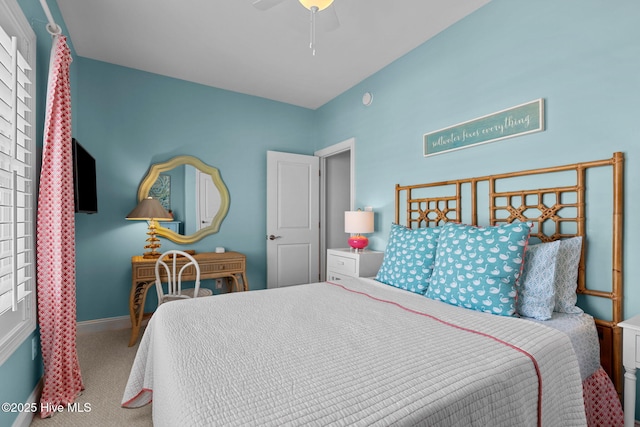 carpeted bedroom with ceiling fan and baseboards