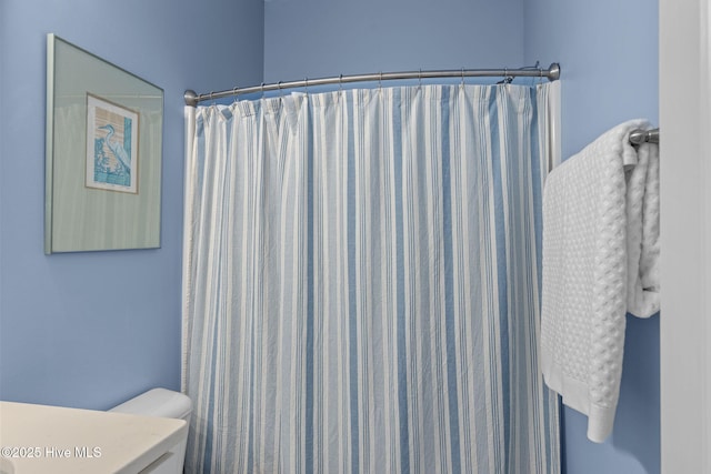 full bathroom featuring toilet and a shower with shower curtain