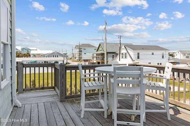 deck with a residential view and outdoor dining space