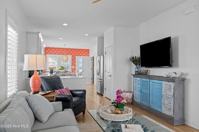 living area with light wood-style flooring, recessed lighting, baseboards, and a ceiling fan