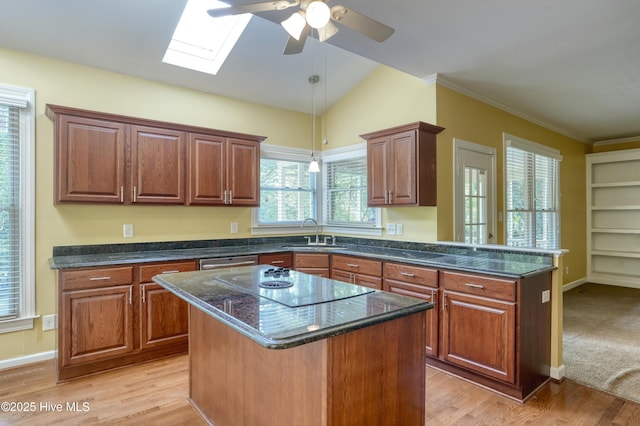 kitchen featuring a ceiling fan, a peninsula, electric cooktop, a sink, and light wood-style flooring