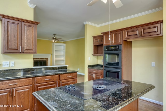 kitchen with brown cabinets, a ceiling fan, baseboards, and black appliances