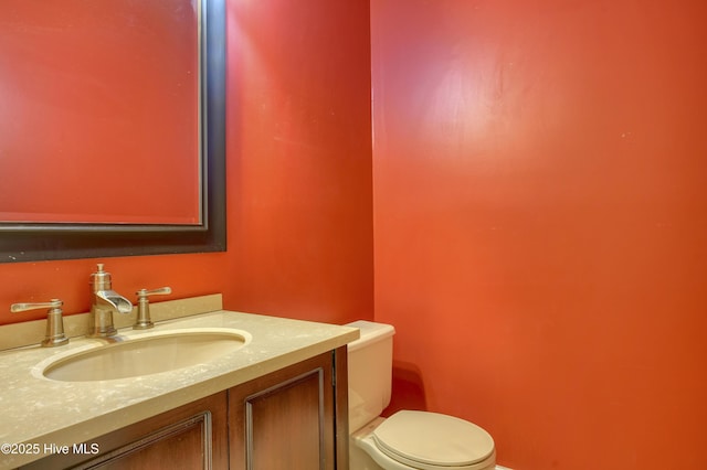 half bathroom featuring vanity and toilet