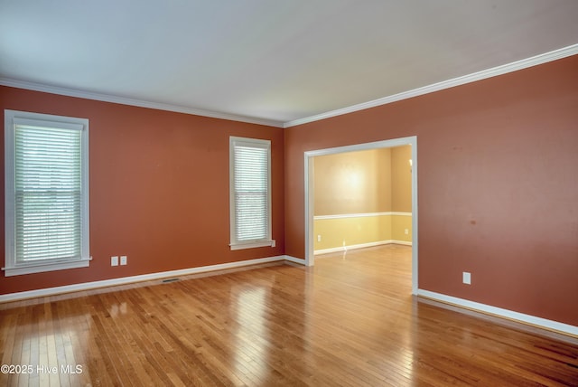 unfurnished room featuring a healthy amount of sunlight, baseboards, and hardwood / wood-style floors
