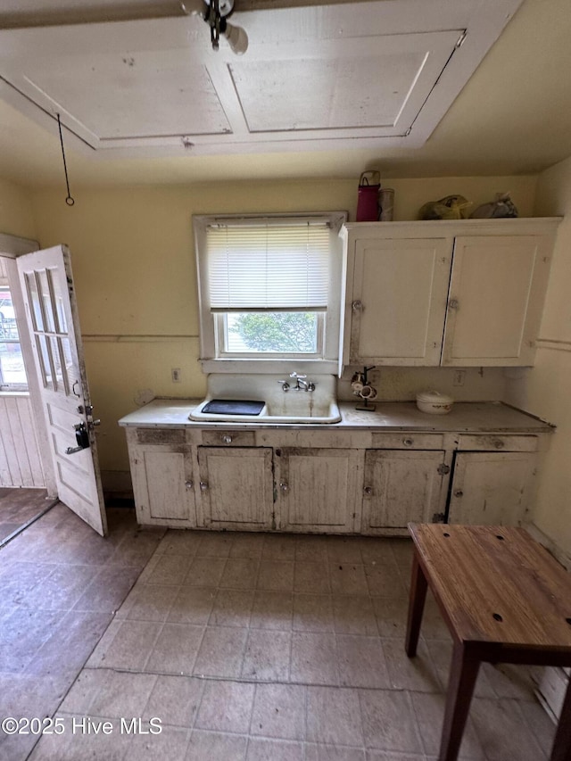 300 W Bryant St, Enfield, NC 27823 - kitchen featuring white cabinets, stone finish floor, and light countertops