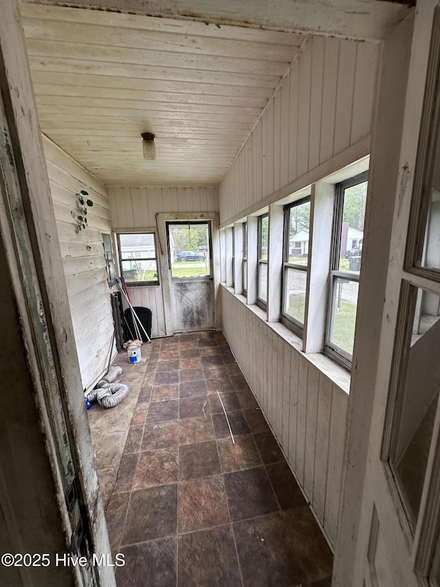 300 W Bryant St, Enfield, NC 27823 - unfurnished sunroom featuring stone finish flooring, wood walls, and a wealth of natural light