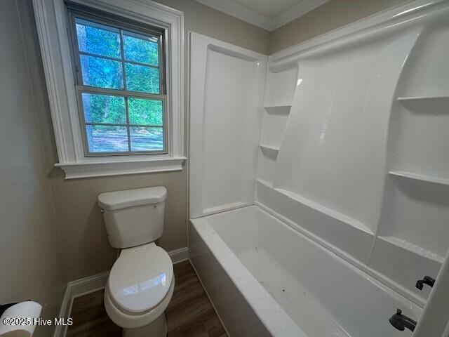 bathroom featuring wood finished floors, baseboards, and toilet