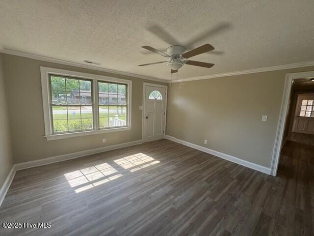 interior space with dark wood finished floors, ornamental molding, baseboards, a textured ceiling, and ceiling fan