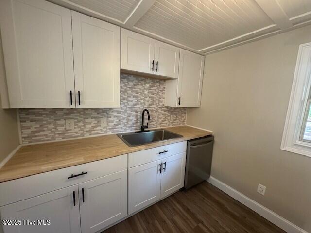 kitchen with dishwasher, backsplash, baseboards, and a sink