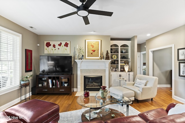 living room with visible vents, ceiling fan, wood finished floors, and a wealth of natural light