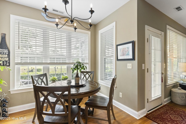 dining room featuring visible vents, baseboards, a healthy amount of sunlight, and an inviting chandelier