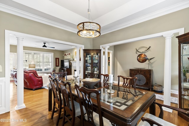 dining room with ornate columns, crown molding, ceiling fan, and wood finished floors