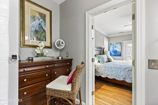 bedroom featuring crown molding and wood finished floors