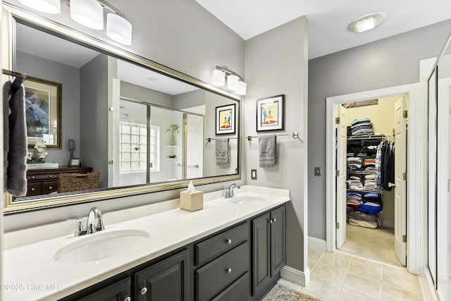 full bathroom featuring a sink, a walk in closet, a stall shower, and double vanity