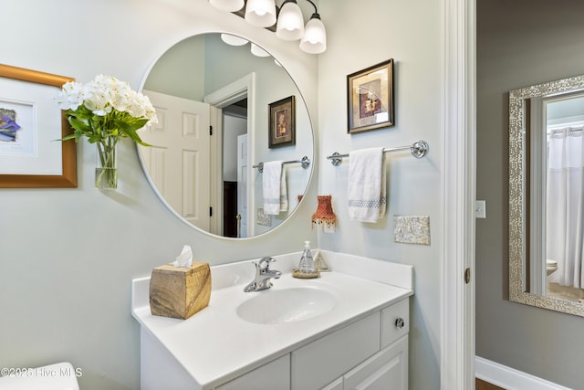 bathroom featuring vanity, toilet, and a chandelier
