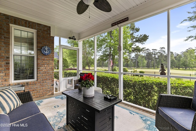 sunroom / solarium featuring ceiling fan