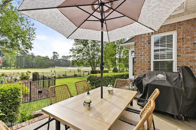 view of patio / terrace featuring a grill, fence, and outdoor dining space