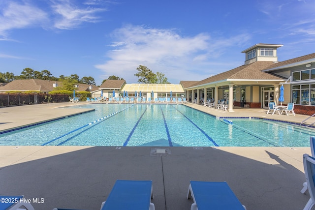 pool with a patio area and fence
