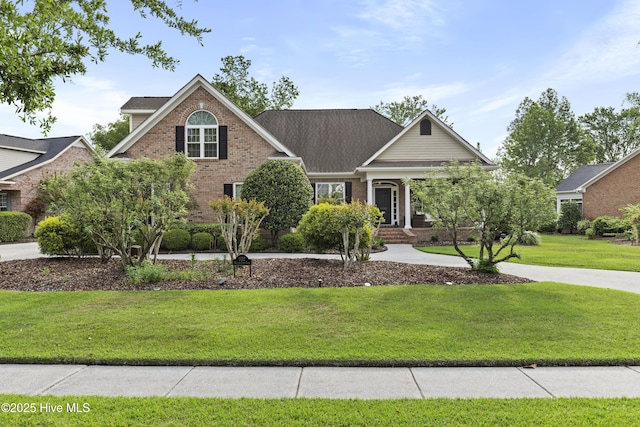 view of front of home with a front yard and brick siding