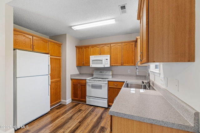 719 Oak Branches Close Close SE, Leland, NC 28451 - kitchen with white appliances, a sink, dark wood finished floors, brown cabinetry, and a textured ceiling