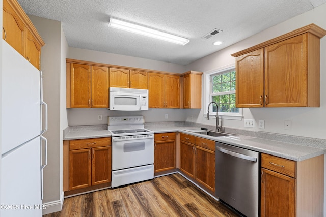 719 Oak Branches Close Close SE, Leland, NC 28451 - kitchen with white appliances, a sink, dark wood-style flooring, light countertops, and a textured ceiling