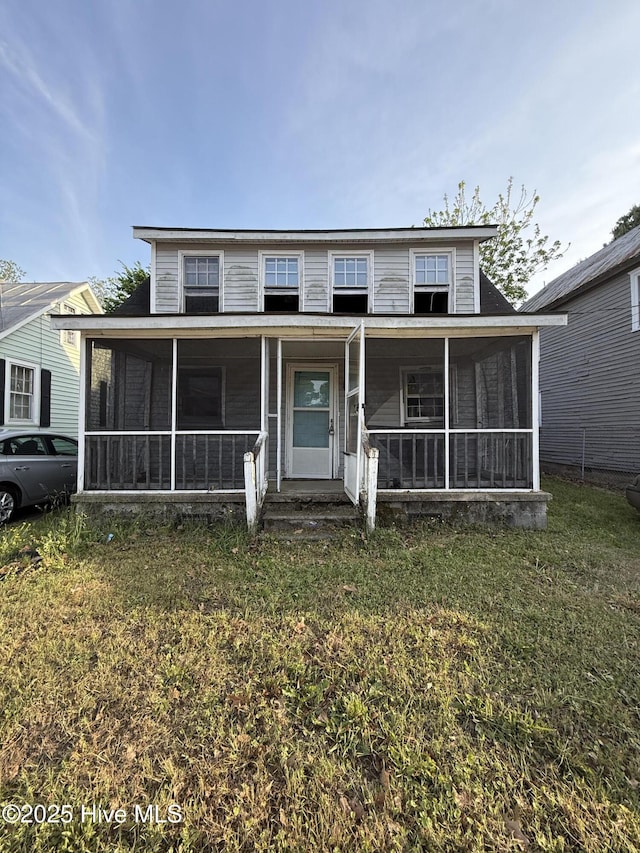 view of front of house with a front lawn and a sunroom
